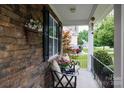Cozy front porch featuring comfortable seating, stone accents, and decorative hanging plants at 2405 Emma Grace Ln, Rock Hill, SC 29732