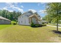 Beautifully landscaped yard with a two-story home featuring stone accents and manicured bushes at 2606 Cheverny Pl, Concord, NC 28027