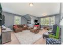 Comfortable carpeted living room with plush furniture, arcade game, and natural light at 2606 Cheverny Pl, Concord, NC 28027