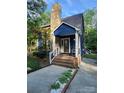 Charming blue home features a stone chimney and inviting front porch with brick steps and walkway at 27092 Village Dr, Fort Mill, SC 29708
