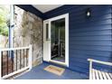 Close-up of front porch featuring stone accents, blue siding, and a 'Welcome' mat at the entrance at 27092 Village Dr, Fort Mill, SC 29708