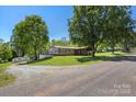 Exterior showcasing the house, the detached shed, with a circular driveway and ample parking at 2942 Denwood Dr, Claremont, NC 28610