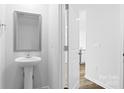 Half bath features a pedestal sink, modern fixtures, and a sleek design at 3132 Ora Smith Rd, Lincolnton, NC 28092