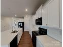 Bright kitchen with white cabinets, black appliances, and a spacious center island at 3629 Cerelia Ln, Denver, NC 28037