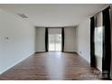 Spacious living room with wood flooring, a sliding glass door, and large windows at 3629 Cerelia Ln, Denver, NC 28037
