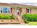 Close-up of the front entrance with red door, white railing, and landscaping at 3903 Graywood Dr, Gastonia, NC 28052