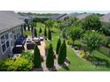 Aerial view of a beautifully landscaped backyard with a patio, outdoor furniture, and a well-maintained lawn at 5064 Lassen Volcanic Trl, Lancaster, SC 29720
