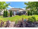 Spacious backyard features a patio with outdoor seating, a lush lawn, and mature trees and landscaping at 5064 Lassen Volcanic Trl, Lancaster, SC 29720