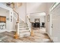 Bright entryway with wood floors, carpeted stairs, and an open view into the dining room with large windows at 5832 Lagrande Dr, Charlotte, NC 28269