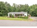 Exterior view of a charming home with a covered porch and a well-maintained lawn at 6213 Golden Oak Ln, Denver, NC 28037