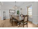 Spacious dining room with a large wooden table, modern chandelier, and lots of natural light at 82120 Standing Oak Dr, Charlotte, NC 28278