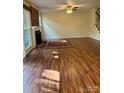 Open living room featuring hardwood floors, fireplace, and ample natural light from large windows at 9125 N Vicksburg Park Ct, Charlotte, NC 28210