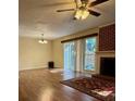 Cozy living room with fireplace, hardwood floors, and sliding glass door with backyard views at 9125 N Vicksburg Park Ct, Charlotte, NC 28210