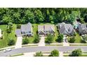 An aerial view of a home with well-manicured lawns, mature trees, and a long driveway in a suburban neighborhood at 10129 Loch Lomond Dr, Charlotte, NC 28278