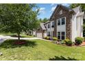 Well maintained front yard of this two-story home boasts lush green grass, landscaping, and a brick-lined flower bed at 10129 Loch Lomond Dr, Charlotte, NC 28278