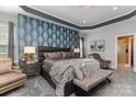 Luxurious main bedroom features a patterned accent wall, plush bedding, and elegant decor at 10203 Loch Lomond Dr, Charlotte, NC 28278