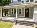 Inviting front porch area with a classic swing, decorative wreath, and a welcoming entrance at 1025 Old Us 80 Hwy, Gold Hill, NC 28071