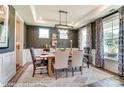 Elegant dining room featuring a modern chandelier, tray ceiling, and large windows with patterned curtains at 126 Longwood Rd # 52, Mooresville, NC 28115