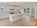 Bright, modern kitchen with white cabinets, stainless steel appliances, and a large center island at 129 French St, Charlotte, NC 28216