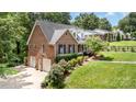 Beautiful brick home with a three-car garage, lush greenery, and well-maintained lawn in a desirable location at 139 Palaside Ne Dr, Concord, NC 28025
