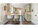 Modern kitchen features neutral green cabinets, stainless steel appliances, granite countertops, and hardwood floors at 14533 Holly Springs Dr, Huntersville, NC 28078