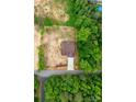 An aerial view of a home showcasing its brown roof and driveway amidst lush greenery and surrounding trees at 1471 Marshbrooke Ln, Catawba, NC 28609