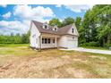 An eye-level view of a charming two-story home with white siding, a covered porch, and an attached garage at 1471 Marshbrooke Ln, Catawba, NC 28609