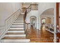 Grand foyer features a curved staircase, hardwood floors, and elegant archways at 1500 Lookout Cir, Waxhaw, NC 28173