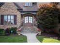 Close-up of a brick home's entrance with stone steps and decorative flower pots at 1500 Lookout Cir, Waxhaw, NC 28173