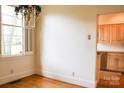 Bright dining room with hardwood floors, shutters, chandelier and an open doorway to the kitchen at 153 Perrin Pl, Charlotte, NC 28207