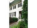 Charming exterior featuring a symmetrical facade, black shutters, and lush landscaping at 153 Perrin Pl, Charlotte, NC 28207
