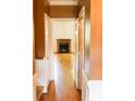 Inviting hallway with hardwood floors leading to a bright room featuring a fireplace at 153 Perrin Pl, Charlotte, NC 28207