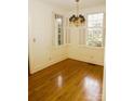 Sunlit living room with hardwood floors, large windows, and a vintage chandelier at 153 Perrin Pl, Charlotte, NC 28207