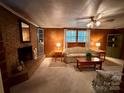 Cozy living room with brick fireplace, wood-paneled walls, and comfortable seating at 211 S Slack St, Albemarle, NC 28001
