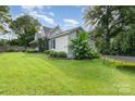 Wide yard with partial view of the side of the home and landscaping at 300 S Hudson Ave, Spencer, NC 28159