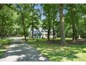 Nestled in a wooded area with a long driveway, this charming home features a spacious yard and mature trees at 316 Wade Hampton Dr, Matthews, NC 28104