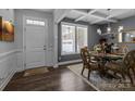 Dining room features paneled walls, a glass table, ornate chairs, decorative chandelier, and coffered ceiling at 322 Ethan Ln, Rock Hill, SC 29732