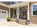 Inviting front porch with rocking chairs, decorative plants, and a brick facade, creating a cozy entrance at 322 Ethan Ln, Rock Hill, SC 29732