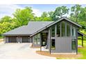 Modern home exterior with sleek lines, large windows, and a three-car garage, set against a lush, green backdrop at 3304 Mar Vista Cir, Charlotte, NC 28209