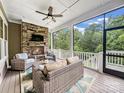 Relaxing screened porch features a stone fireplace, ceiling fan and wooded views at 501 Preservation Dr, Fort Mill, SC 29715