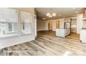 Sun-filled room with hardwood floors throughout, large windows, and an open concept to the kitchen and dining area at 5205 Raging Creek Dr # 122, Indian Trail, NC 28079