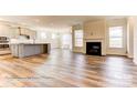 Open floor plan featuring fireplace, hardwood floors, and plenty of natural light throughout living and kitchen area at 5205 Raging Creek Dr # 122, Indian Trail, NC 28079