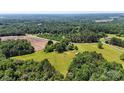 Broad drone shot overlooking land with rolling green spaces and thickly wooded areas at 5740 Crouse Rd, Crouse, NC 28033