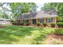 Beautiful brick home with well-manicured lawn, lush landscaping, and traditional shutters at 629 Wingrave Dr, Charlotte, NC 28270