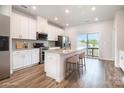Modern kitchen featuring an island with seating, stainless steel appliances, and sliding glass doors to balcony at 7012 Bryce Ave, Charlotte, NC 28217