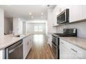 Bright kitchen with white cabinets, stainless steel appliances and granite countertops open to a spacious living area at 7012 Bryce Ave, Charlotte, NC 28217