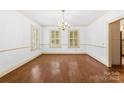Elegant dining room with hardwood floors, natural light from shuttered windows, and a stylish chandelier at 805 S Main St, Mount Holly, NC 28120