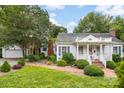 Inviting home featuring a brick walkway, landscaped yard, white trim, and a porch, showcasing its classic architectural style at 805 S Main St, Mount Holly, NC 28120