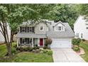 Two-story home with a well-maintained lawn and a charming red front door at 8700 Fox Tail Ln, Huntersville, NC 28078