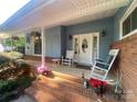 Inviting front porch with rocking chairs, hanging flower baskets, and a decorative wreath on the front door at 903 Woodside Dr, Kings Mountain, NC 28086
